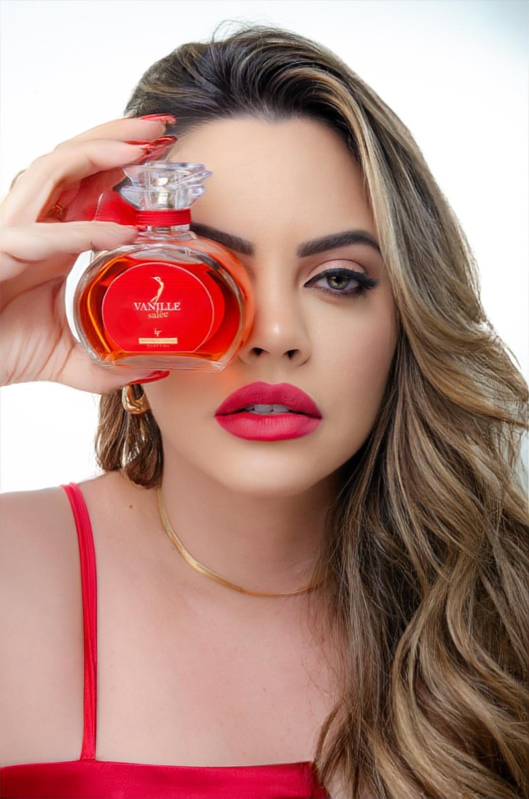 Mulher segurando o frasco Vanille Salée junto ao rosto